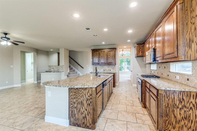 302 Shire Ln, Celina, TX 75009 - kitchen featuring stainless steel appliances, tasteful backsplash, recessed lighting, light stone countertops, and an island with sink