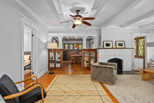 1600 S Adams St, Fort Worth, TX 76104 - living area with decorative columns, a ceiling fan, wood finished floors, ornamental molding, and a brick fireplace