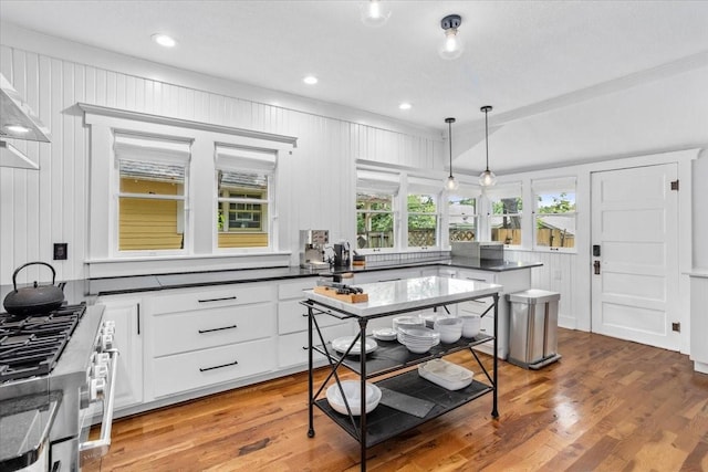 1600 S Adams St, Fort Worth, TX 76104 - kitchen with stainless steel range, dark countertops, white cabinetry, light wood-type flooring, and hanging light fixtures