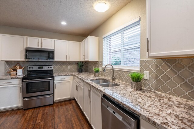 1637 Thornhill Ln, Little Elm, TX 75068 - kitchen with appliances with stainless steel finishes, backsplash, white cabinetry, recessed lighting, and dark wood-style flooring