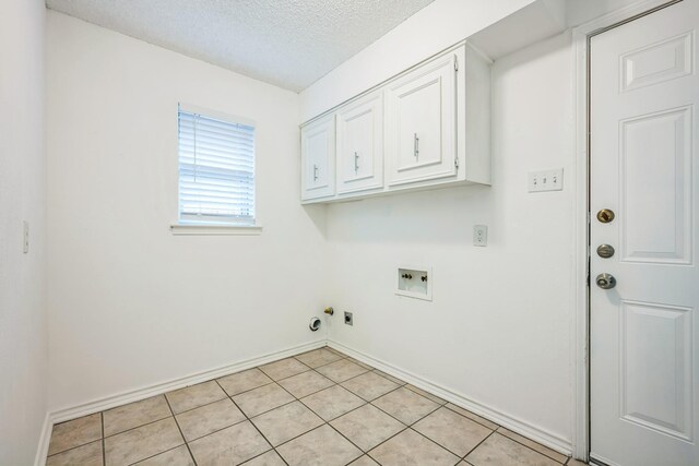 2413 Golden Willow Ln, Richardson, TX 75082 - laundry area with washer hookup, cabinet space, a textured ceiling, light tile patterned floors, and gas dryer hookup
