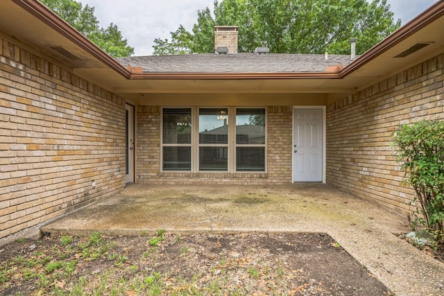 2413 Golden Willow Ln, Richardson, TX 75082 - doorway to property with brick siding, a chimney, a patio area, and a shingled roof