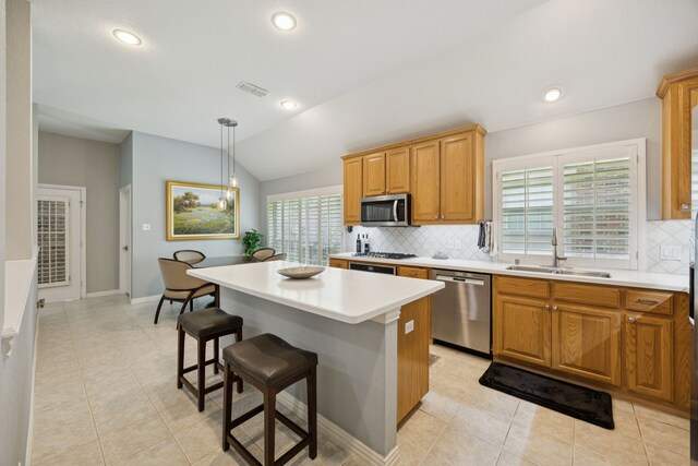 418 Long Cove Ct, Allen, TX 75002 - kitchen featuring appliances with stainless steel finishes, tasteful backsplash, light tile patterned floors, lofted ceiling, and light countertops