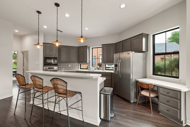 801 Cliffmoor Dr, Keller, TX 76248 - kitchen featuring appliances with stainless steel finishes, built in desk, backsplash, light countertops, and dark wood-type flooring