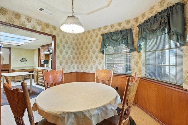 1419 Juniper Ln, Lewisville, TX 75077 - dining area with a wainscoted wall, wallpapered walls, a textured ceiling, and wooden walls