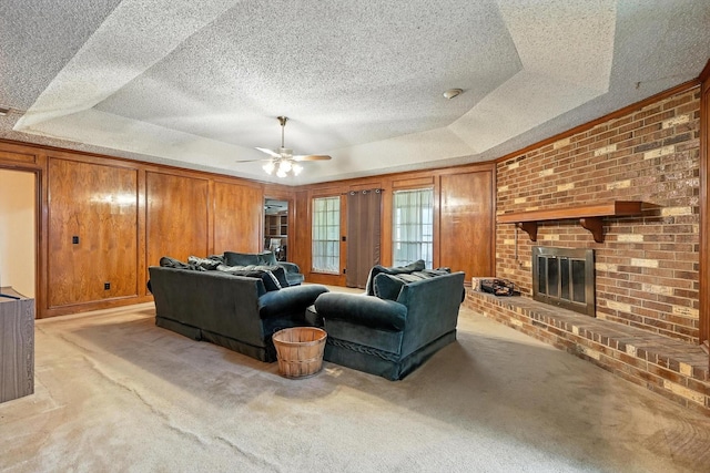 1419 Juniper Ln, Lewisville, TX 75077 - living room featuring a raised ceiling, light carpet, a ceiling fan, a textured ceiling, and a brick fireplace
