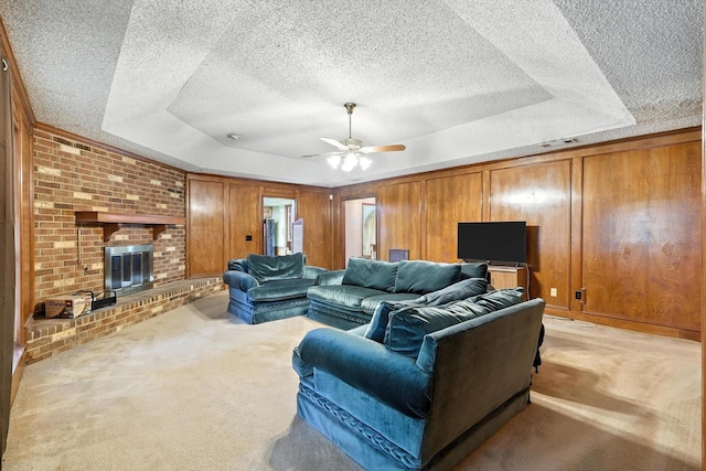 1419 Juniper Ln, Lewisville, TX 75077 - living room with light colored carpet, a textured ceiling, a raised ceiling, a fireplace, and ceiling fan