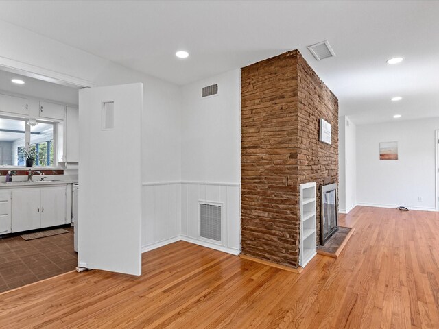 4608 Winthrop Ave E, Fort Worth, TX 76116 - unfurnished living room featuring light wood-style flooring, a fireplace, wine cooler, recessed lighting, and wainscoting