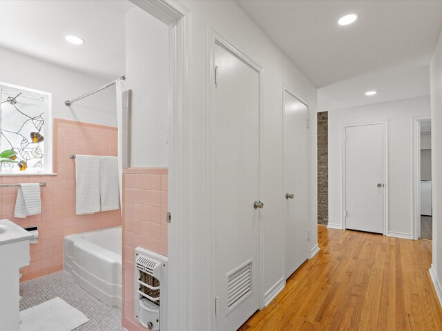 4608 Winthrop Ave E, Fort Worth, TX 76116 - hallway featuring heating unit, tile walls, recessed lighting, light wood-style floors, and wainscoting
