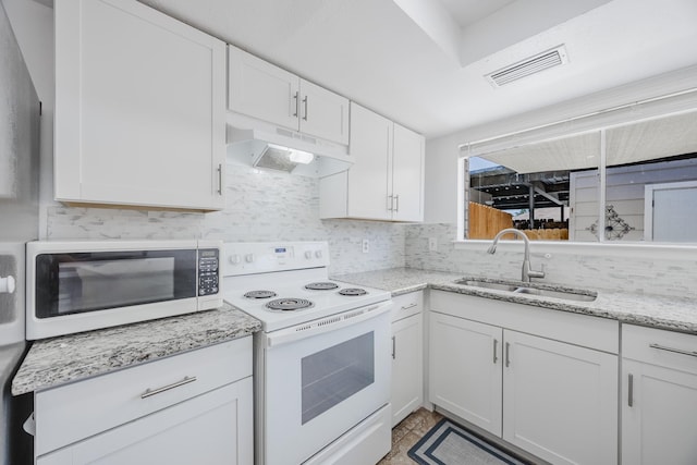 22 W Townhouse Ln Unit 34, Grand Prairie, TX 75052 - kitchen featuring white appliances, under cabinet range hood, decorative backsplash, white cabinetry, and light stone countertops