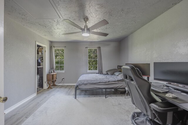 22 W Townhouse Ln Unit 34, Grand Prairie, TX 75052 - bedroom with a desk, wood finished floors, a textured wall, a textured ceiling, and a ceiling fan