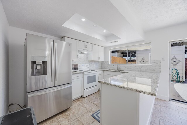 22 W Townhouse Ln Unit 34, Grand Prairie, TX 75052 - kitchen featuring stainless steel fridge with ice dispenser, white range with electric cooktop, under cabinet range hood, a tray ceiling, and a peninsula