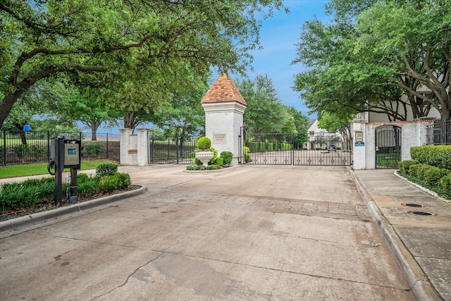 17227 Lechlade Ln, Dallas, TX 75252 - view of concrete road with a gate, curbs, and a gated entry