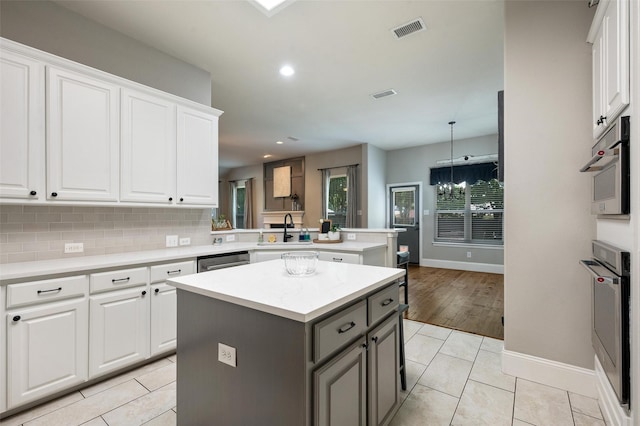 2413 Bachman Dr, Flower Mound, TX 75028 - kitchen with a peninsula, a kitchen island, light countertops, white cabinets, and recessed lighting
