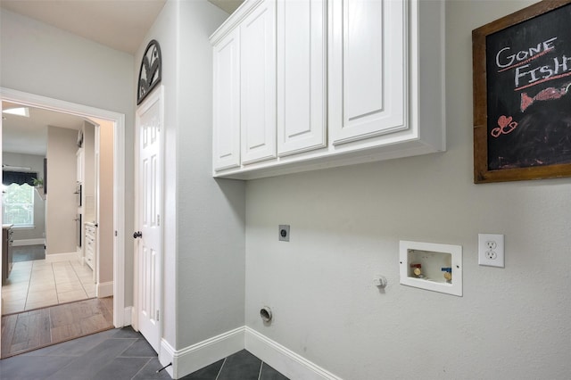2413 Bachman Dr, Flower Mound, TX 75028 - laundry room with hookup for an electric dryer, dark tile patterned floors, washer hookup, hookup for a gas dryer, and cabinet space