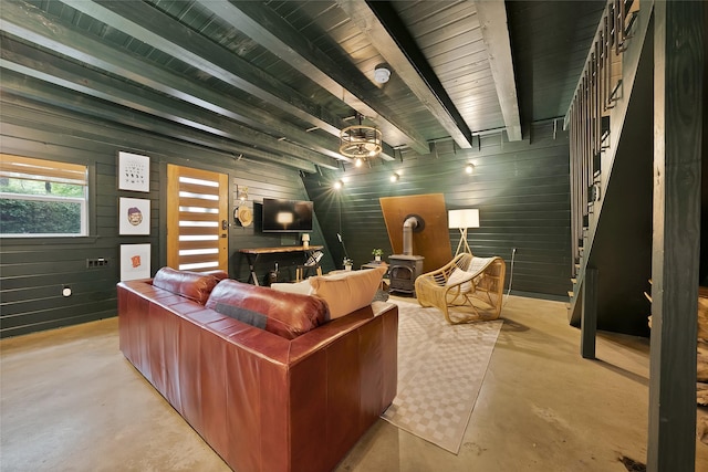 120 Lakeway Ln, Gun Barrel City, TX 75156 - living area featuring concrete flooring, beamed ceiling, wooden walls, and a wood stove
