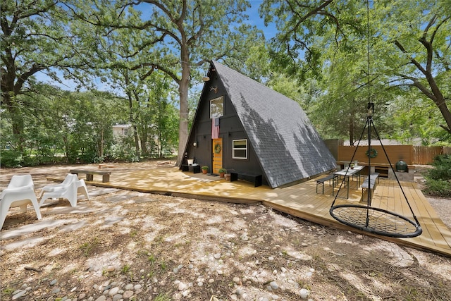 120 Lakeway Ln, Gun Barrel City, TX 75156 - view of side of home featuring a shingled roof, a deck, and view of scattered trees
