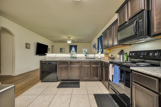 5921 Obsidian Creek Dr, Fort Worth, TX 76179 - kitchen featuring black appliances, a peninsula, dark brown cabinetry, ceiling fan, and arched walkways
