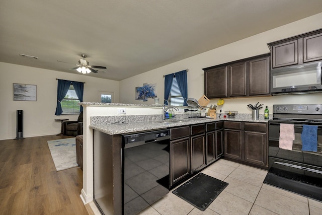5921 Obsidian Creek Dr, Fort Worth, TX 76179 - kitchen featuring black appliances, a peninsula, dark brown cabinets, ceiling fan, and light stone countertops