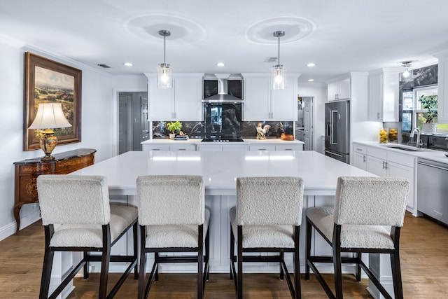 9867 Dripping Springs Rd, Denison, TX 75021 - kitchen featuring appliances with stainless steel finishes, wall chimney exhaust hood, tasteful backsplash, a kitchen island, and light countertops