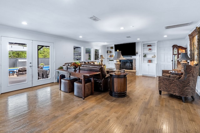 9867 Dripping Springs Rd, Denison, TX 75021 - living room with ornamental molding, wood finished floors, french doors, recessed lighting, and a stone fireplace