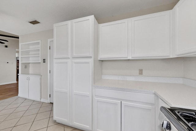 1225 Briarcove Dr, Richardson, TX 75081 - kitchen featuring stainless steel range oven, light countertops, and white cabinetry
