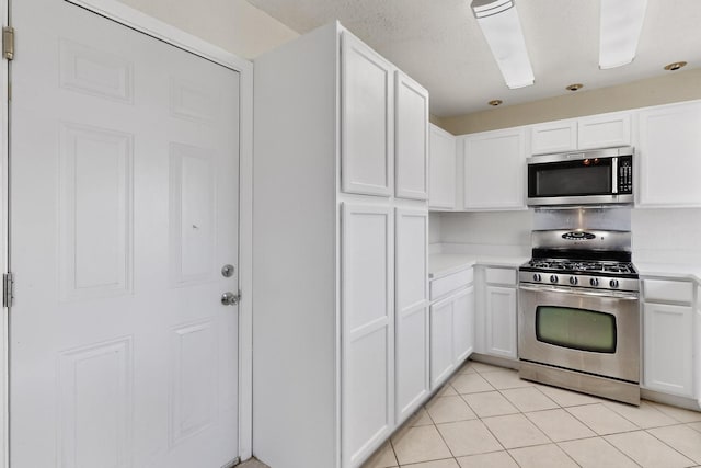1225 Briarcove Dr, Richardson, TX 75081 - kitchen featuring stainless steel appliances, light countertops, white cabinetry, and light tile patterned flooring