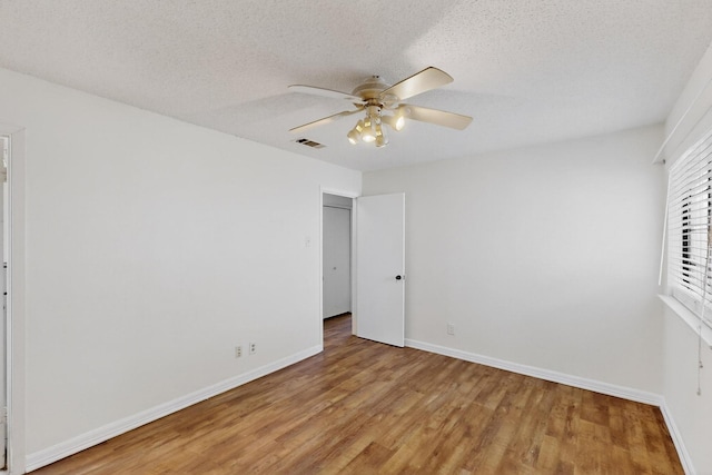 1225 Briarcove Dr, Richardson, TX 75081 - unfurnished bedroom with light wood finished floors, ceiling fan, and a textured ceiling