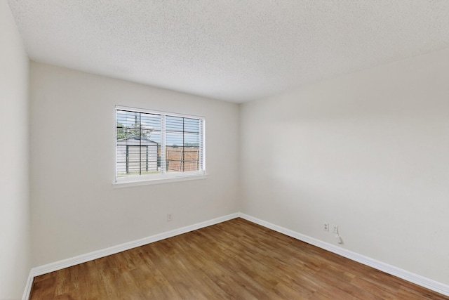 1225 Briarcove Dr, Richardson, TX 75081 - empty room with wood finished floors and a textured ceiling