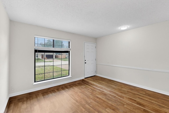 1225 Briarcove Dr, Richardson, TX 75081 - spare room featuring a textured ceiling and wood finished floors