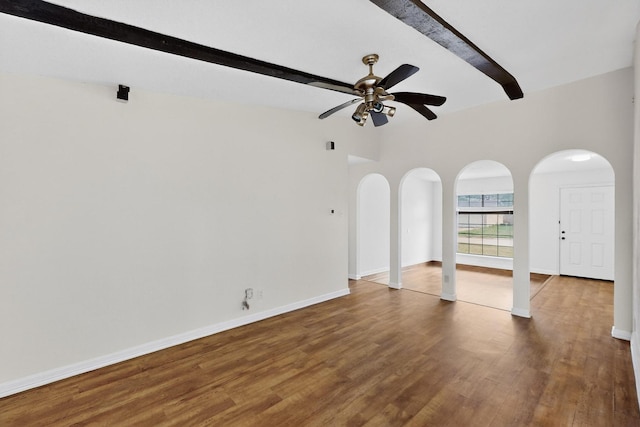 1225 Briarcove Dr, Richardson, TX 75081 - empty room with arched walkways, beamed ceiling, ceiling fan, and wood finished floors