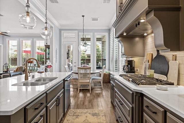 1861 Snapdragon Rd, Frisco, TX 75033 - kitchen with appliances with stainless steel finishes, hardwood / wood-style floors, light countertops, plenty of natural light, and crown molding