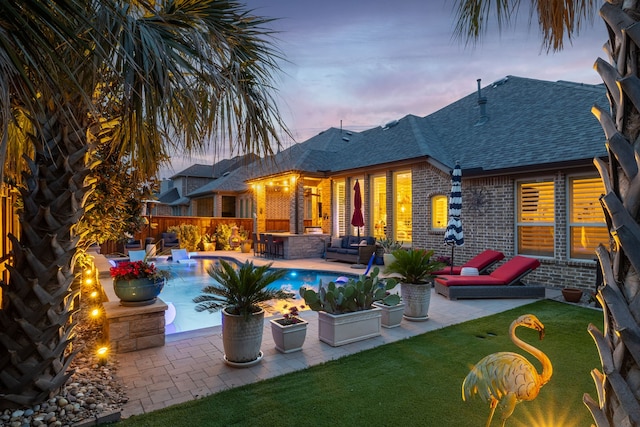 1861 Snapdragon Rd, Frisco, TX 75033 - back of house at dusk featuring brick siding, a shingled roof, a patio area, outdoor lounge area, and a fenced backyard