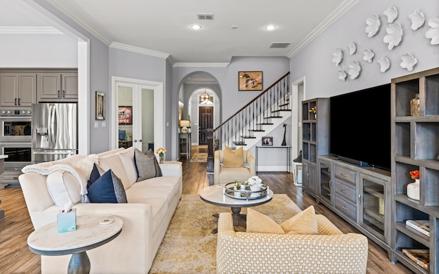 1861 Snapdragon Rd, Frisco, TX 75033 - living room with arched walkways, ornamental molding, stairway, wood finished floors, and recessed lighting
