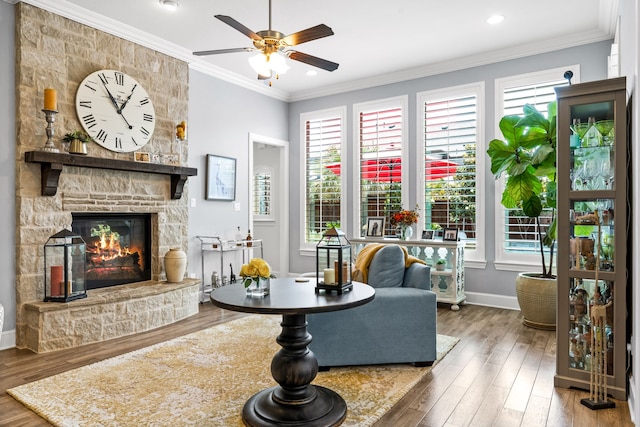 1861 Snapdragon Rd, Frisco, TX 75033 - living area with plenty of natural light, a ceiling fan, a stone fireplace, wood finished floors, and crown molding
