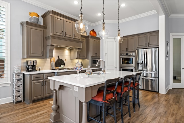 1861 Snapdragon Rd, Frisco, TX 75033 - kitchen featuring appliances with stainless steel finishes, wood finished floors, light countertops, backsplash, and crown molding