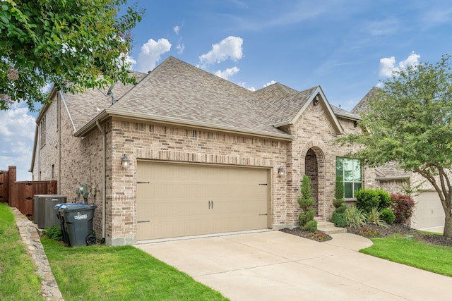 4001 Bamboo Trl, Mckinney, TX 75071 - french country home featuring a shingled roof, an attached garage, brick siding, and concrete driveway