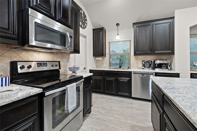 1501 Birdsong Ct, Midlothian, TX 76065 - kitchen featuring stainless steel appliances, dark cabinetry, backsplash, and light stone countertops