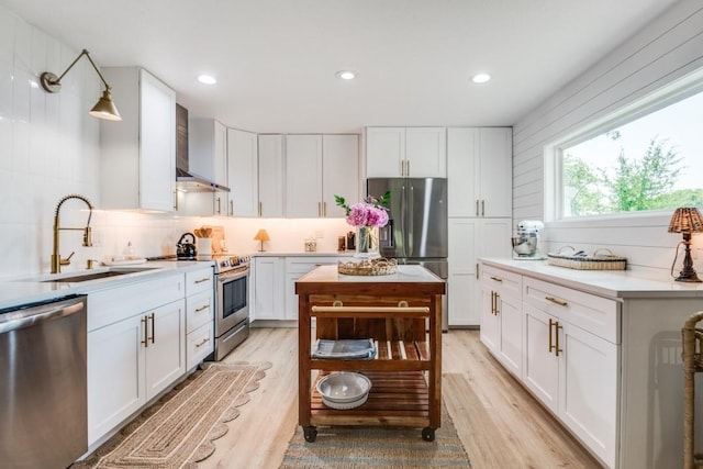 105 Causeway Ct, Gun Barrel City, TX 75156 - kitchen featuring stainless steel appliances, wall chimney exhaust hood, light wood-style flooring, white cabinetry, and recessed lighting