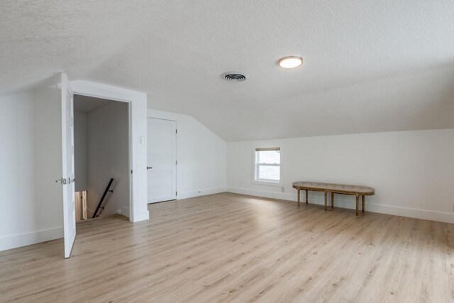 105 Causeway Ct, Gun Barrel City, TX 75156 - additional living space with vaulted ceiling, a textured ceiling, and light wood-type flooring