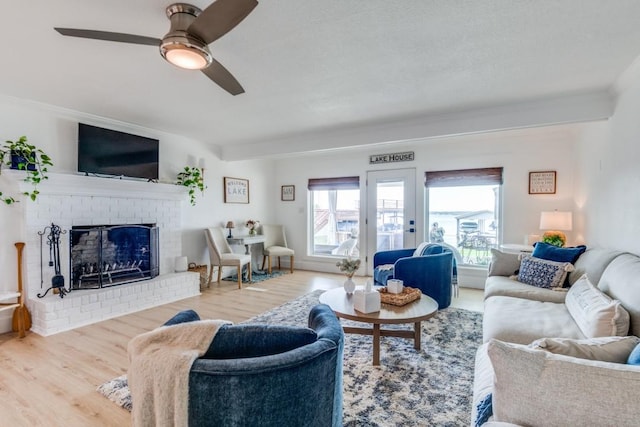 105 Causeway Ct, Gun Barrel City, TX 75156 - living room featuring wood finished floors, a ceiling fan, a fireplace, and ornamental molding