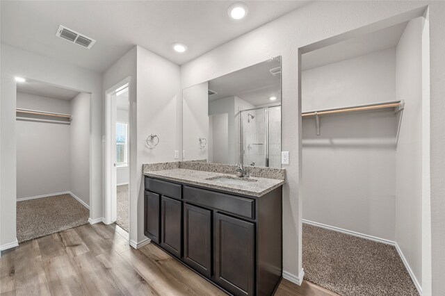 6941 Guadalupe Rd, China Spring, TX 76633 - full bath featuring a walk in closet, a shower stall, vanity, wood finished floors, and recessed lighting