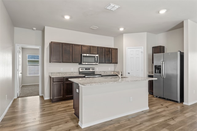 6941 Guadalupe Rd, China Spring, TX 76633 - kitchen featuring stainless steel appliances, dark brown cabinets, light wood-style flooring, a kitchen island with sink, and recessed lighting