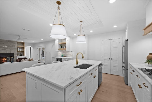 7150 Blairview Dr, Dallas, TX 75230 - kitchen featuring recessed lighting, light wood-style floors, a kitchen island with sink, white cabinetry, and stainless steel appliances
