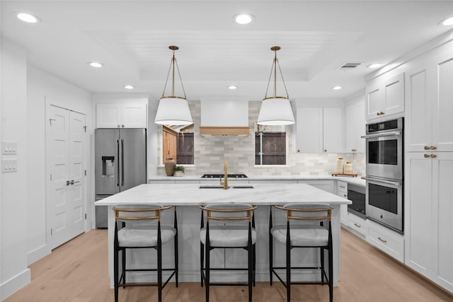 7150 Blairview Dr, Dallas, TX 75230 - kitchen with appliances with stainless steel finishes, a tray ceiling, light wood-type flooring, white cabinetry, and recessed lighting