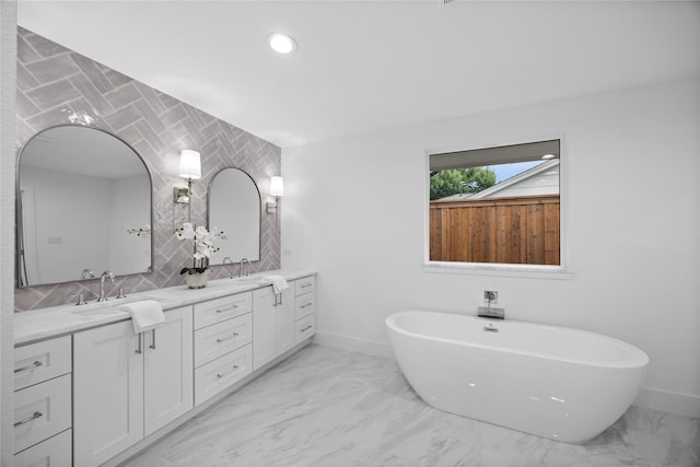 7150 Blairview Dr, Dallas, TX 75230 - full bathroom with double vanity, a freestanding bath, marble finish flooring, recessed lighting, and decorative backsplash