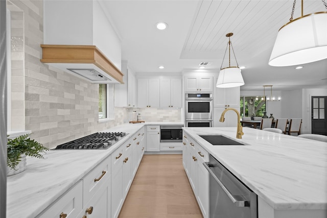 7150 Blairview Dr, Dallas, TX 75230 - kitchen with appliances with stainless steel finishes, healthy amount of natural light, a kitchen island with sink, white cabinets, and recessed lighting
