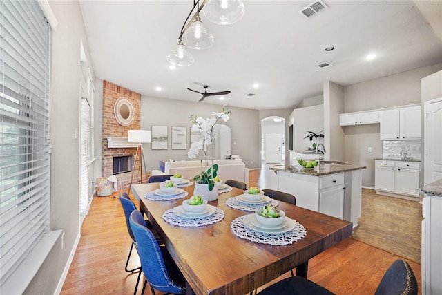 733 Atascosa Ave, Fort Worth, TX 76120 - dining space featuring arched walkways, light wood-style flooring, a fireplace, recessed lighting, and ceiling fan