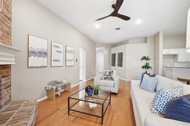 733 Atascosa Ave, Fort Worth, TX 76120 - living area with arched walkways, a ceiling fan, light wood-style floors, a brick fireplace, and recessed lighting