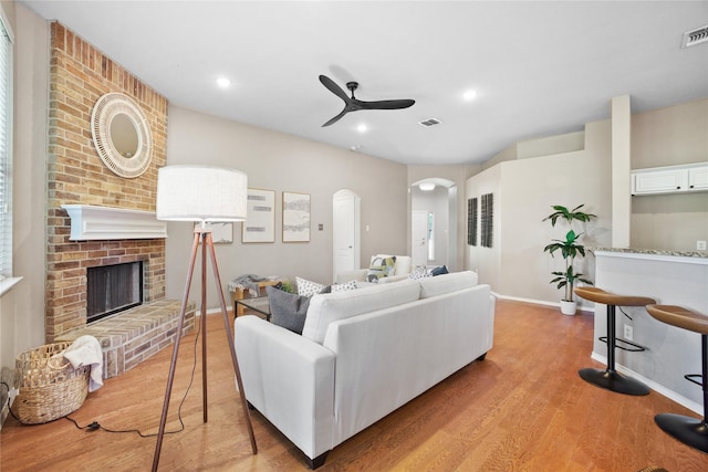 733 Atascosa Ave, Fort Worth, TX 76120 - living room featuring arched walkways, a ceiling fan, light wood finished floors, a fireplace, and recessed lighting